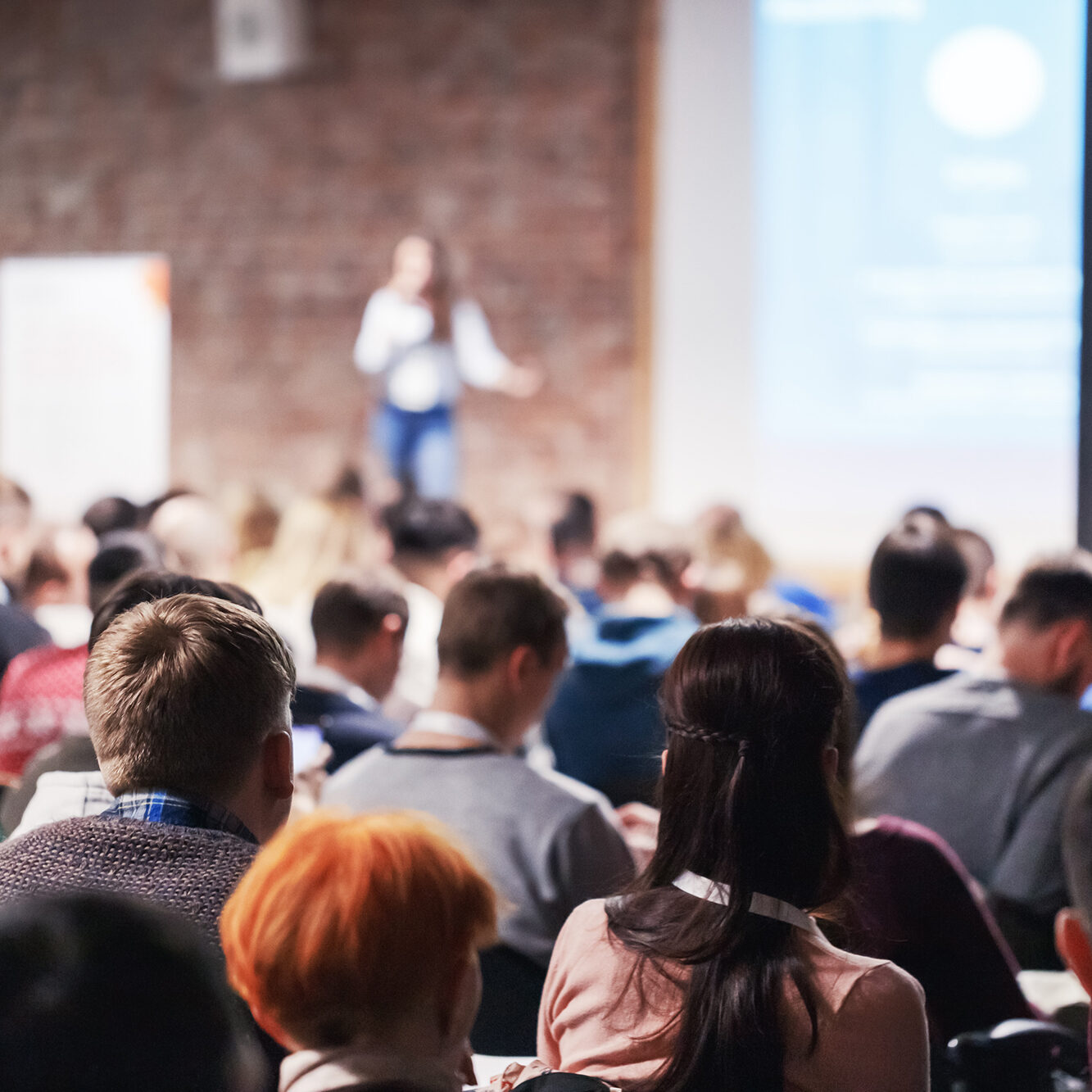 Adult people at conference listen to woman speaker providing lec